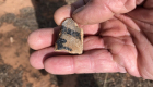 Photo of a small sherd of pottery painted with black markings.