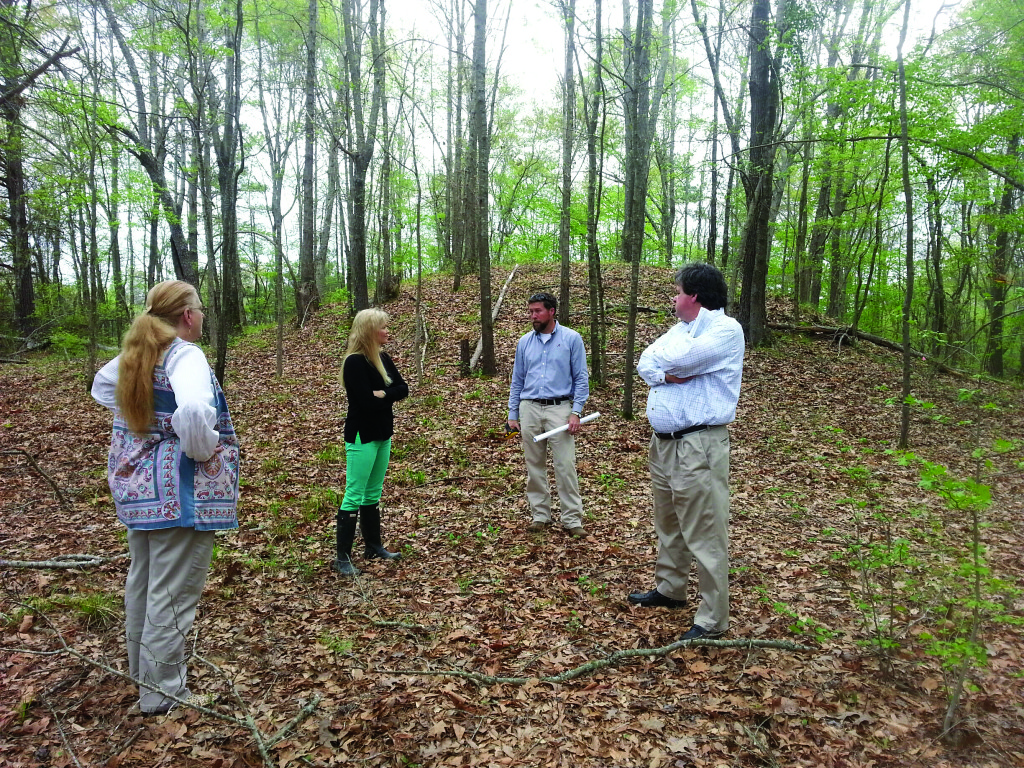 Elizabeth Irwin of the University of Alabama Museums, Jessica Crawford, Southeast regional director for the Conservancy, Matt Gage, director of the Office of the University of Alabama Museums, and Howell Poole, Jr., president of the Bank of Moundville, discuss the significance of the Asphalt Company Mound during a recent site visit.