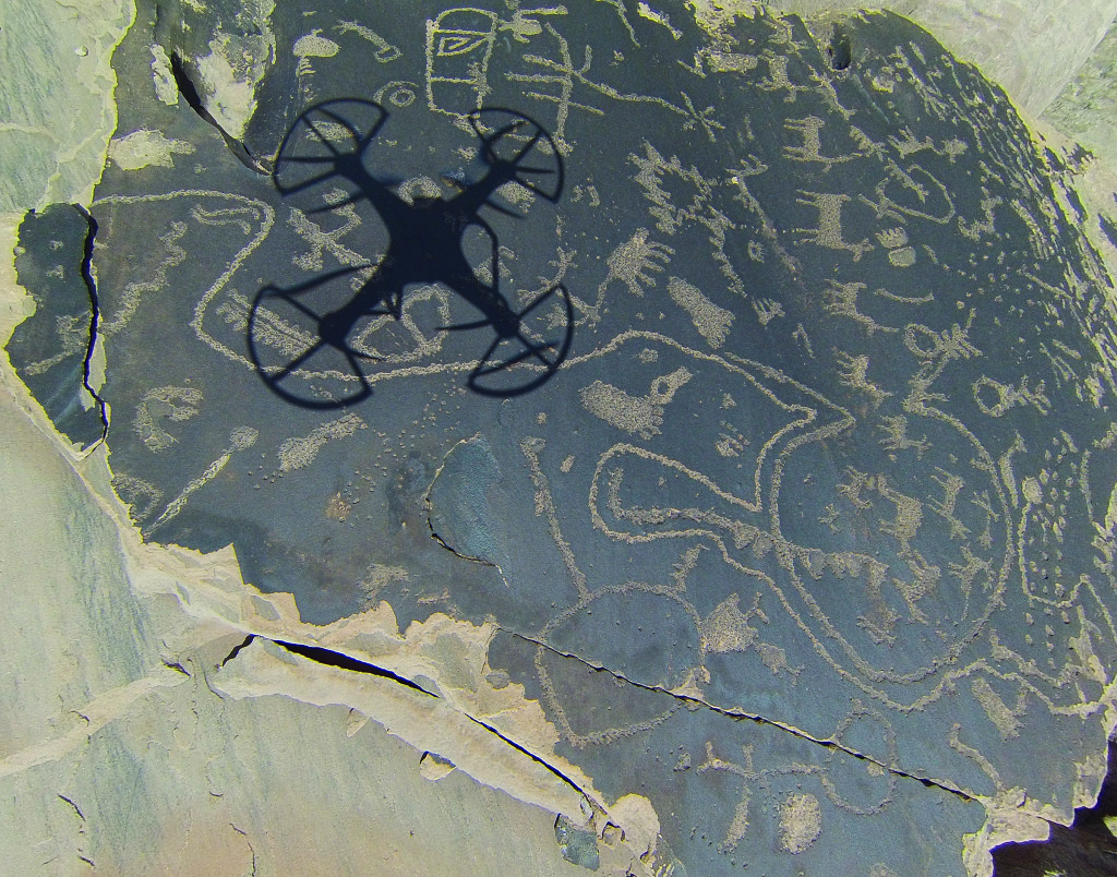 A drone captured its own shadow while photographing a large petroglyph boulder in northeast Arizona. Credit: Rupestrian CyberServices
