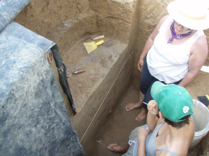 Having discovered human remains in a post pit at the center of a large public building at the Emerald site, Susan Alt (left) and Sarah Baires discuss how to proceed. The remains are not discernable in this photo because only a small portion of the skeleton was exposed. After consulting with the state of Illinois Historic Preservation Agency and descendant communities, the archaeologists left the remains in place. Photo credit, Timothy R. Pauketat
