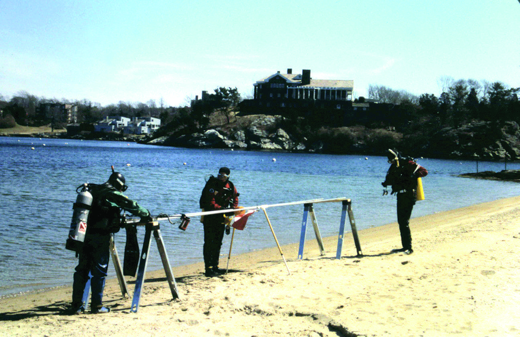 RIMAP divers prepare the underwater frame to take photos of the piece of a ship's structure off the sandy beach in Newport's  Brenton Cove in March 1997. The divers (from left) are Bob Benway, Mark Munro, and Joe Zarzynski.  Credit: RIMAP © 1997
