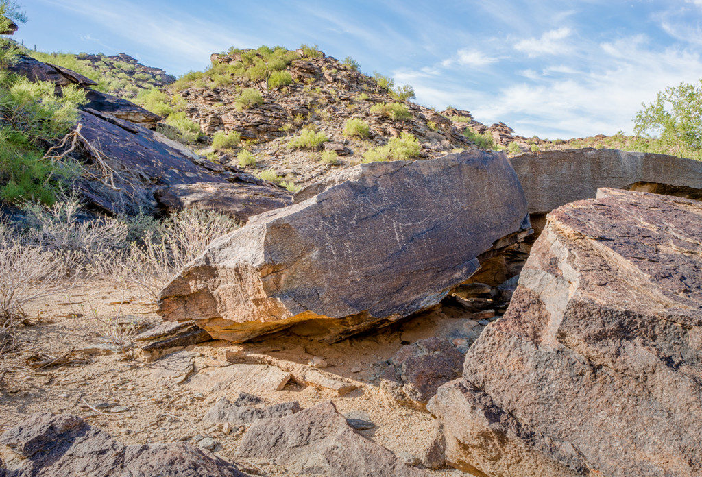 3. Petroglyphs line the interior of an alcove set inside a cluster of large boulders. Placed near a spring, this enclosure lies at the base of a processional causeway that ascends the adjacent ridge. Credit: Paul Vanderveen