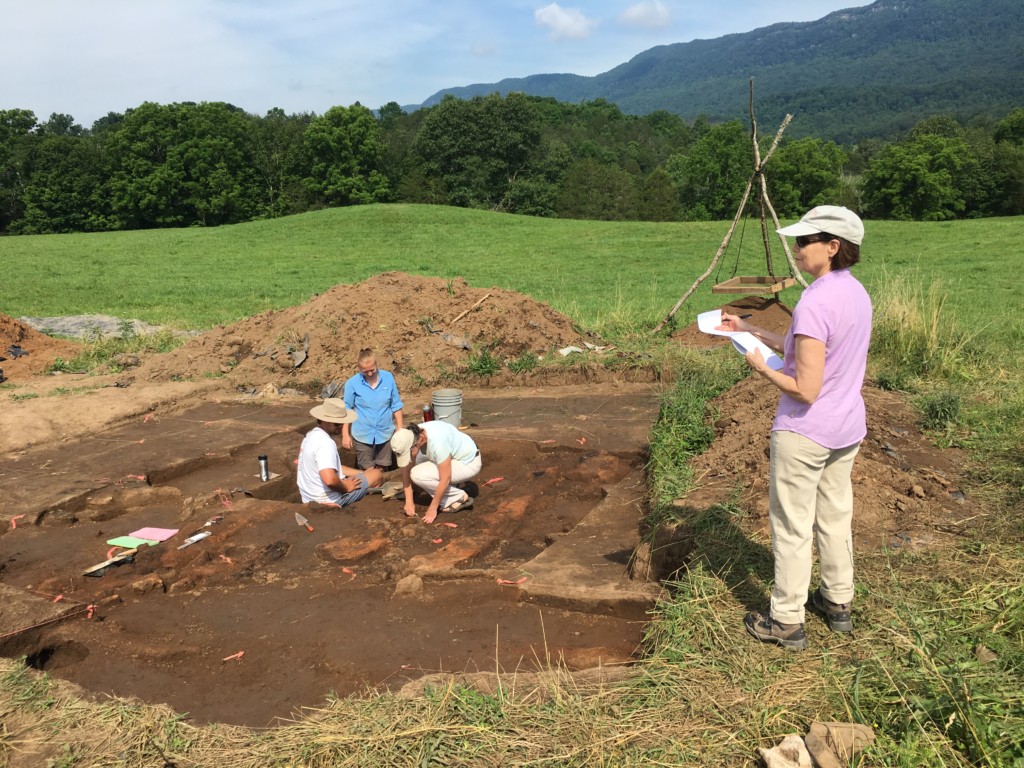 Writer Linda Vaccariello takes notes while Assistant Professor Maureen Meyers shows U of Mississippi undergraduate Conor Foxworth and UM graduate student Emily Warner how to excavate part of the structure wall. The Mound is in the distance. Credit: Charlotte Smith