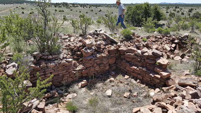 Mark Michel, the president of the Conservancy, walks behind an excavated masonry room. Credit: Jim Walker/The Archaeological Conservancy.