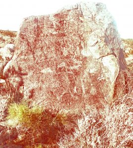 Photo of petroglyphs on a boulder that have been digitally enhanced with D-Stretch